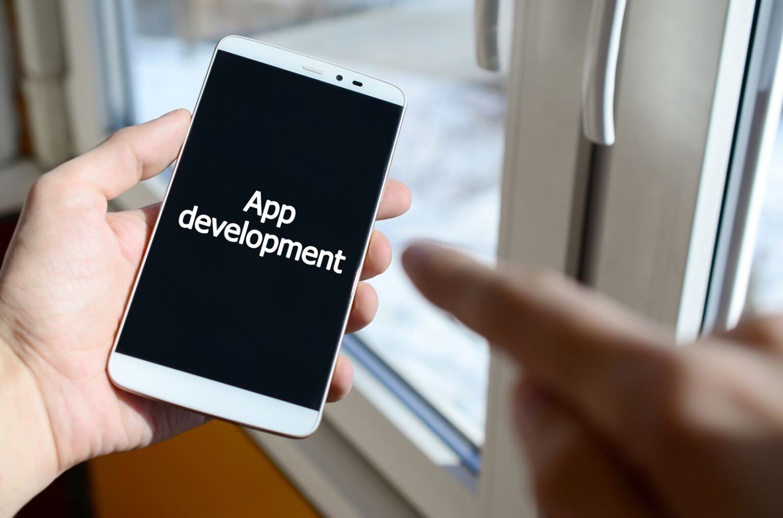 Person holding a smartphone showing a mobile app in development