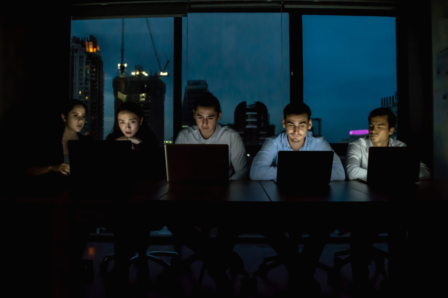 Team reviewing AI automation dashboards in a dark office overlooking the city